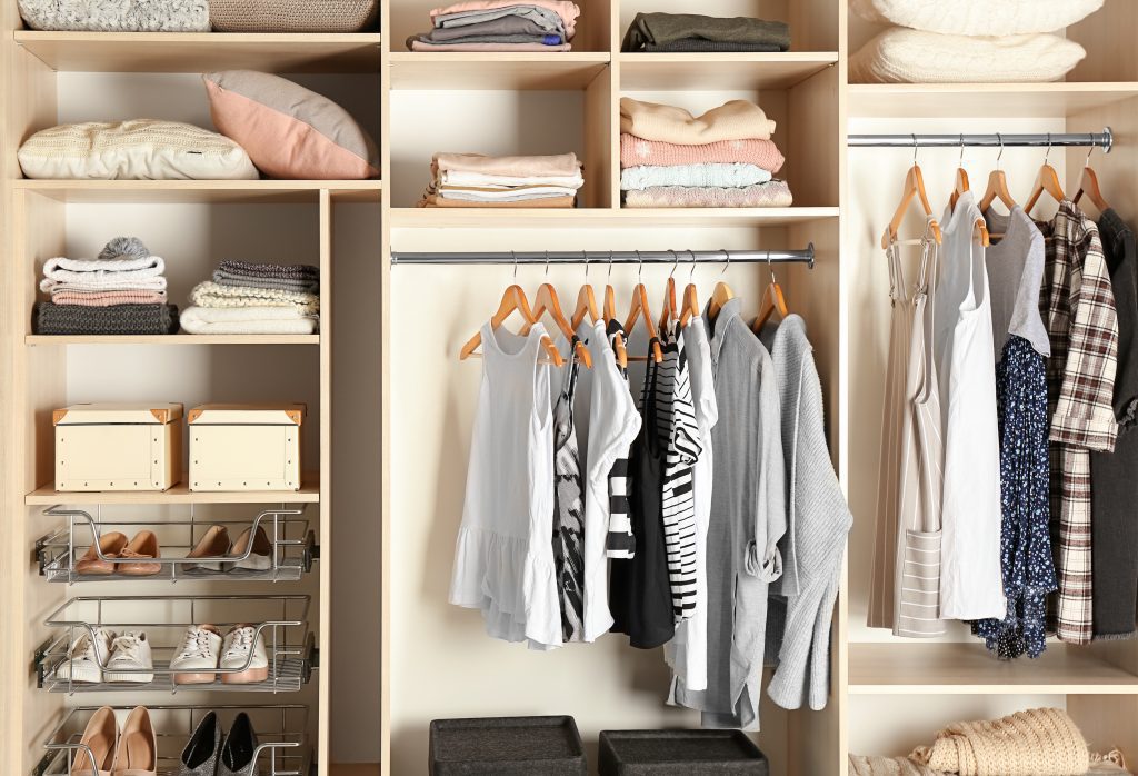 Large organised wardrobe closet with different clothes and shoes