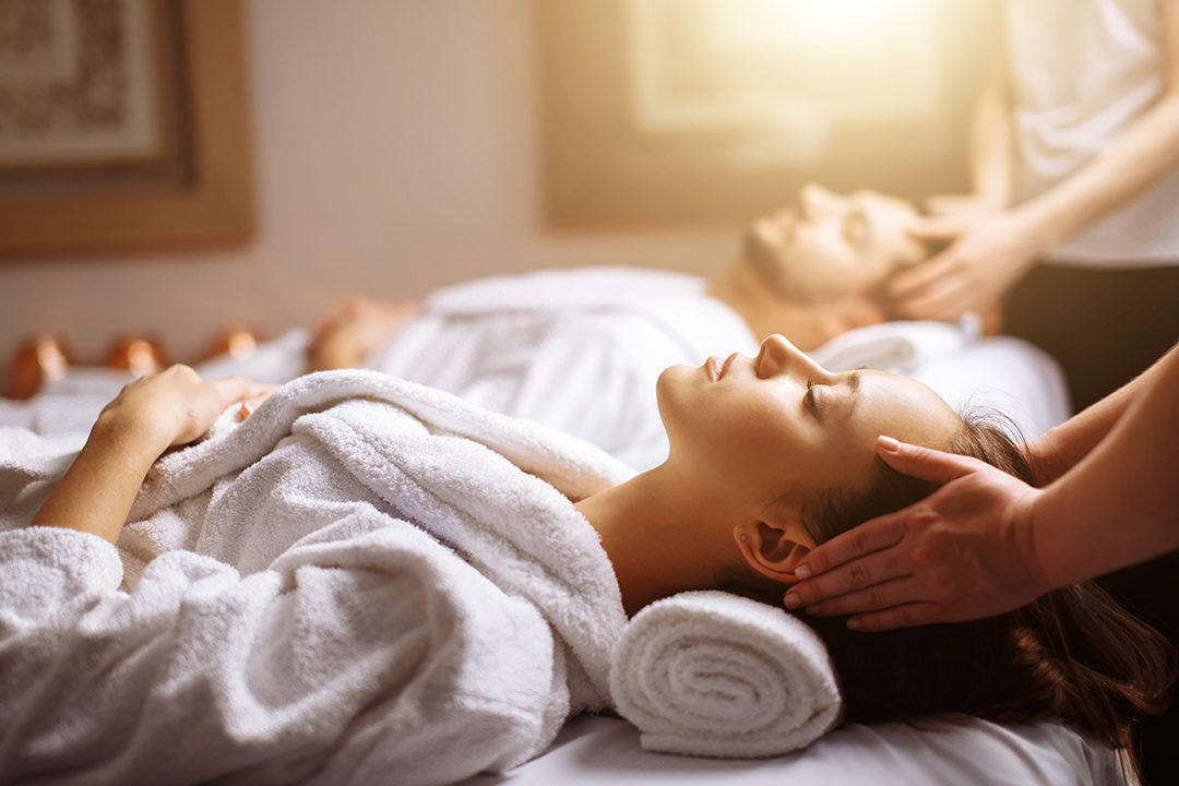 Man and woman in steam bath with towels smiling - Foto de stock